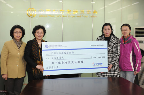 Qin Guoying (L1), Zhen Yan (L2), Tai Xiangmei (R2) and another staff member lift a donation board together. [Women of China/Fan Wenjun]
