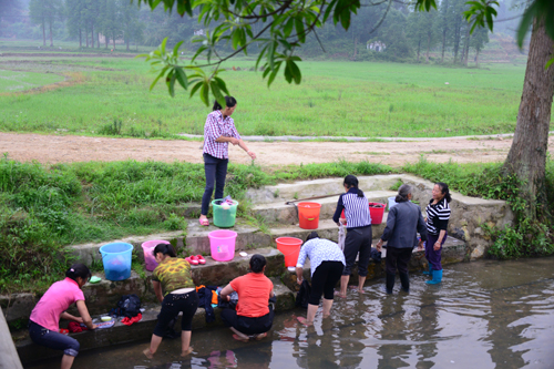 Villagers of Jiangbian Village in Nashan Town of Jinggangshan City who can't use tap water have to wash clothes at the river. [watercellar.cn]